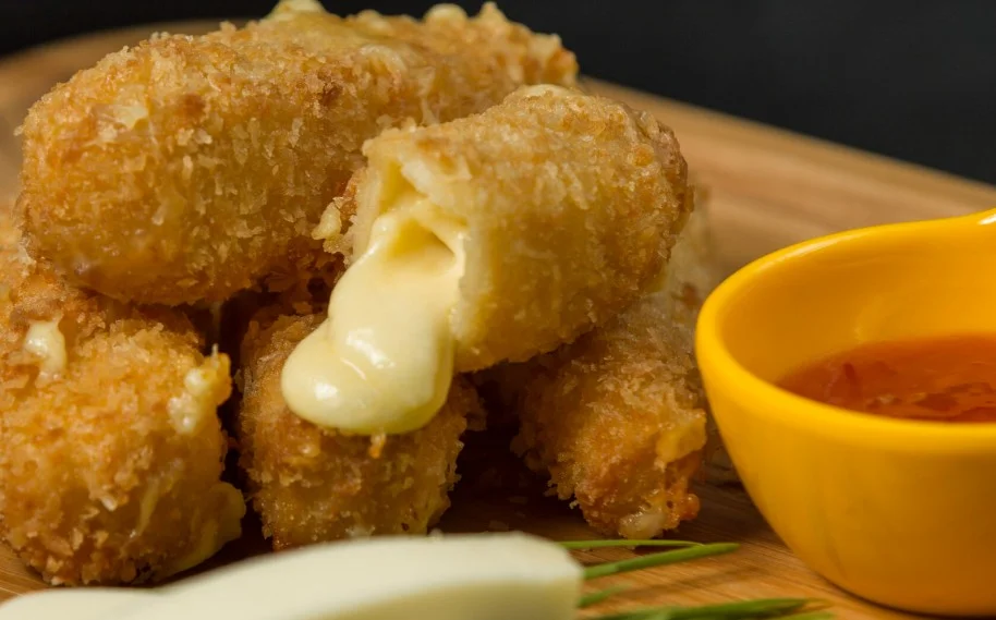 Fried Cheese Sticks - Golden-fried mozzarella sticks with a gooey cheese center, served with marinara sauce.